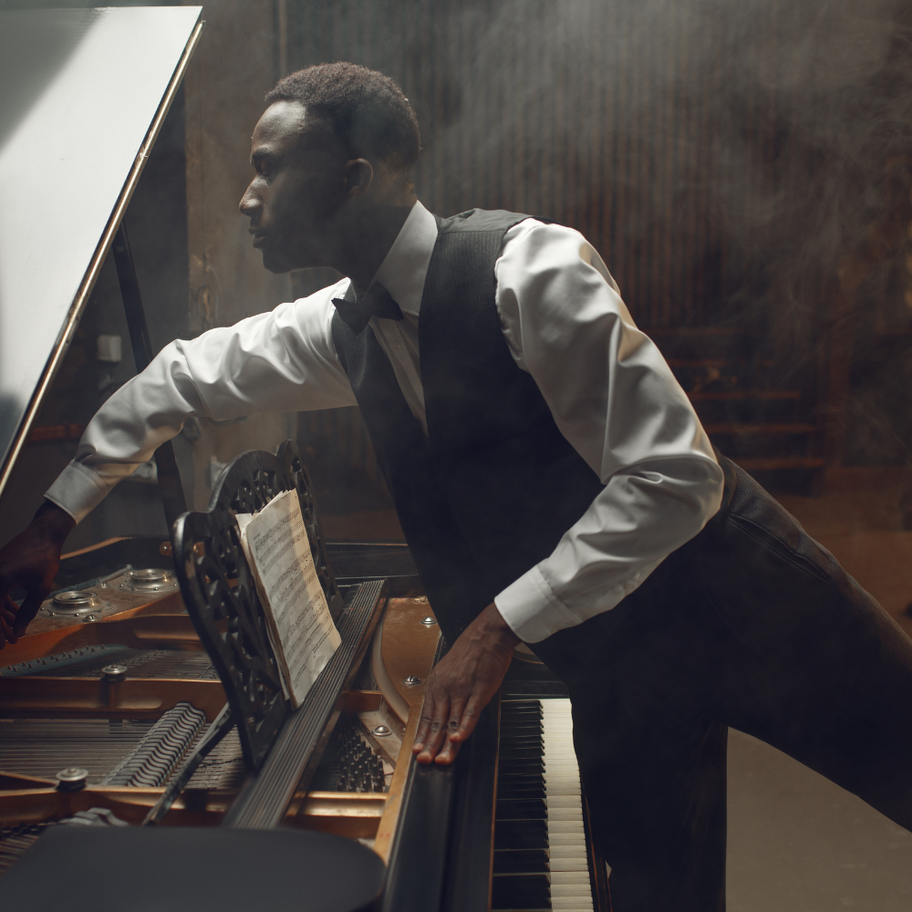 A musician leans across a piano